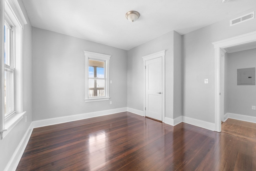 44 Bowdoin Street, Unit 2 Boston, MA 02124 - Photo 25 of 33 an empty room with wooden floor and windows
