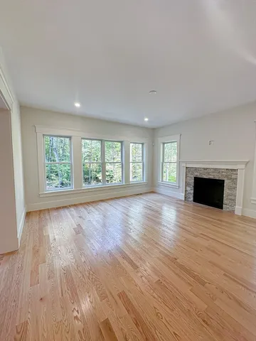 an empty room with large windows and fireplace