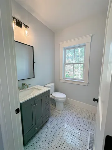 a bathroom with a toilet sink and mirror