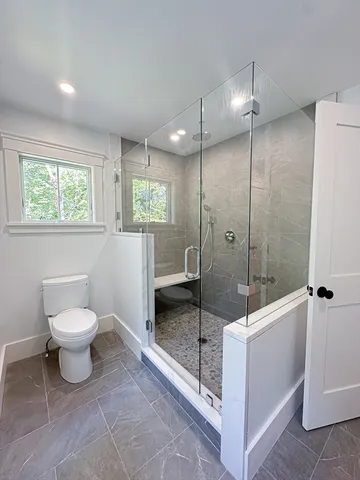 a bathroom with a toilet and a shower