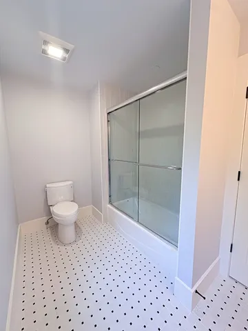 a bathroom with a toilet and a shower