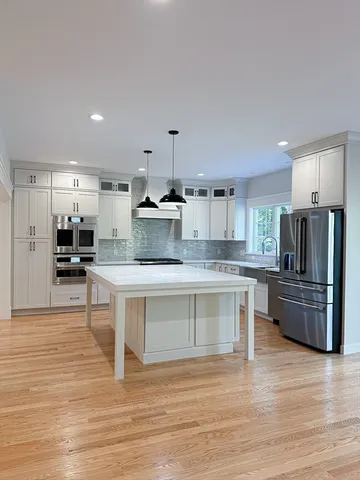 a large kitchen with stainless steel appliances kitchen island granite countertop a large counter top cabinets and furniture