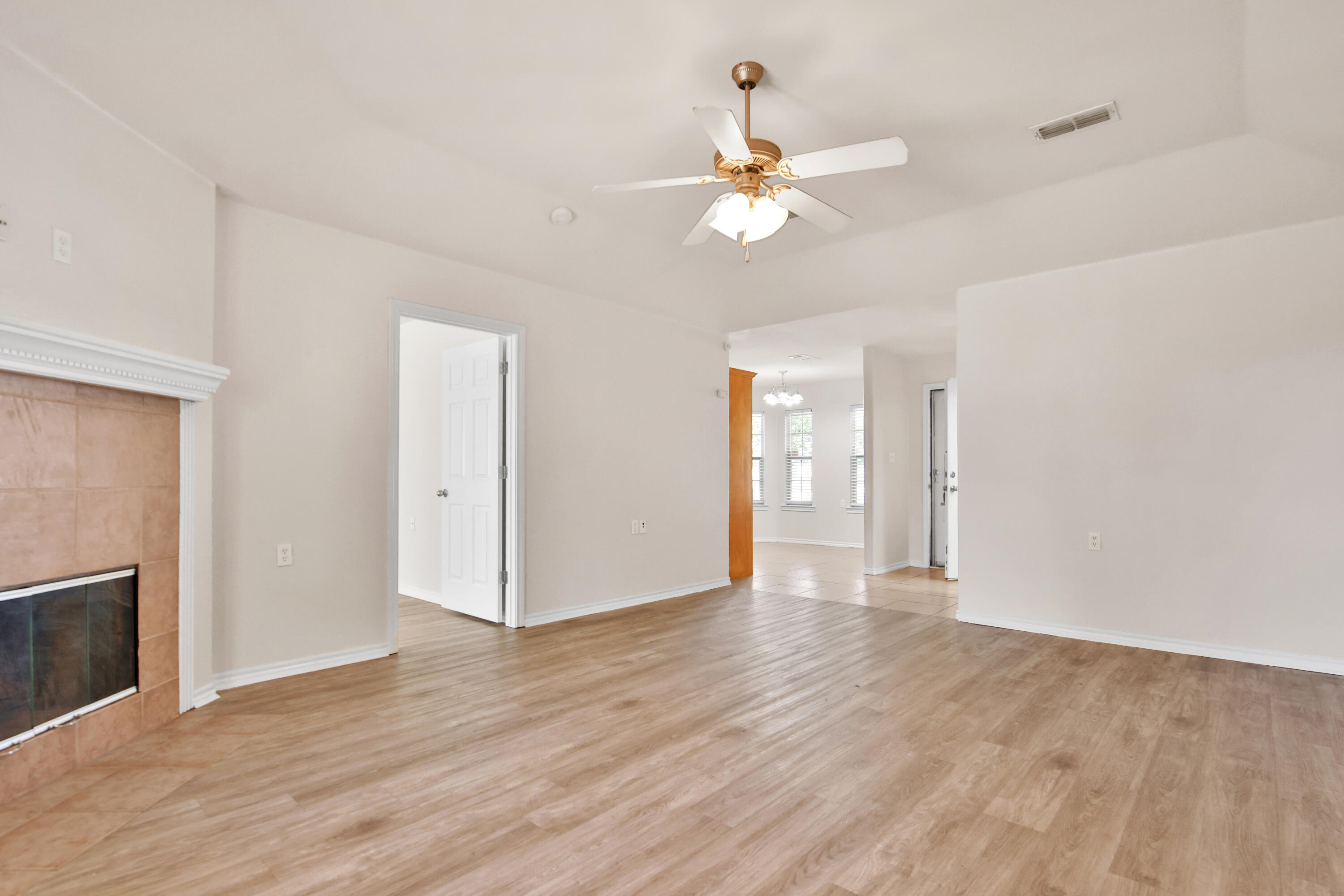 2117 99th Street Lubbock, TX 79423 - Photo 11 of 30 a view of an empty room with wooden floor and fan
