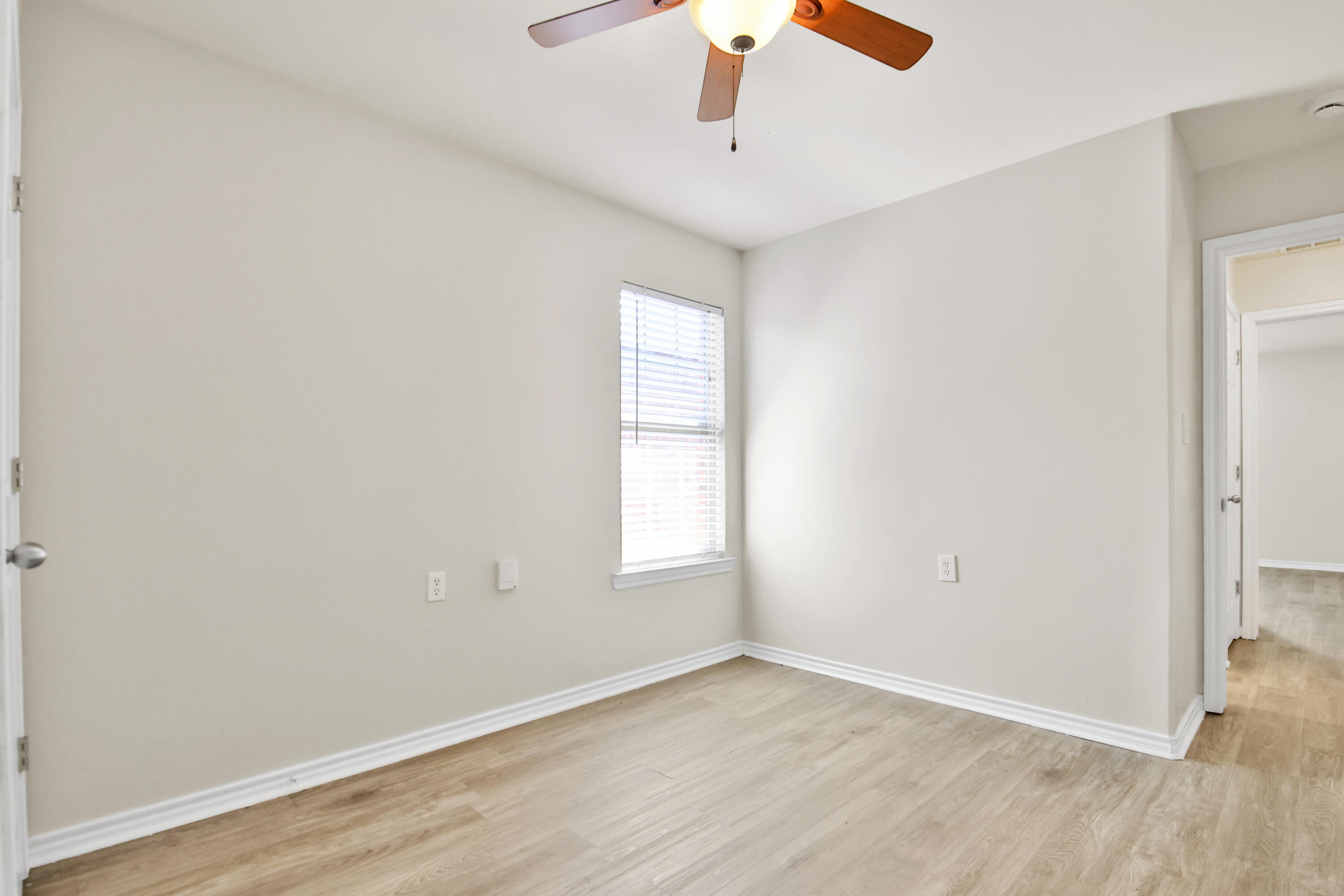 2117 99th Street Lubbock, TX 79423 - Photo 15 of 30 an empty room with wooden floor chandelier fan and windows