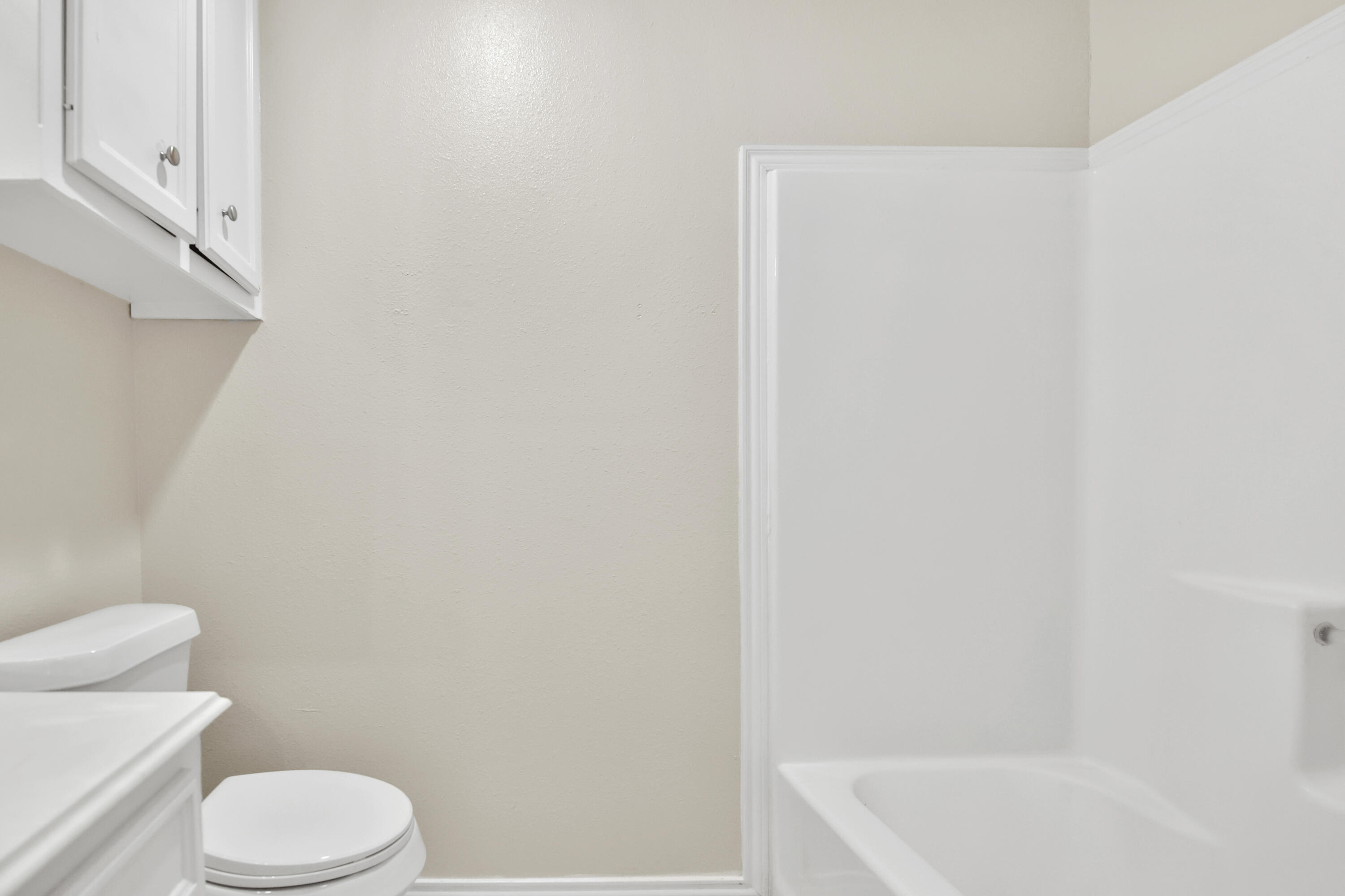 2117 99th Street Lubbock, TX 79423 - Photo 18 of 30 a white toilet sitting next to a bath tub