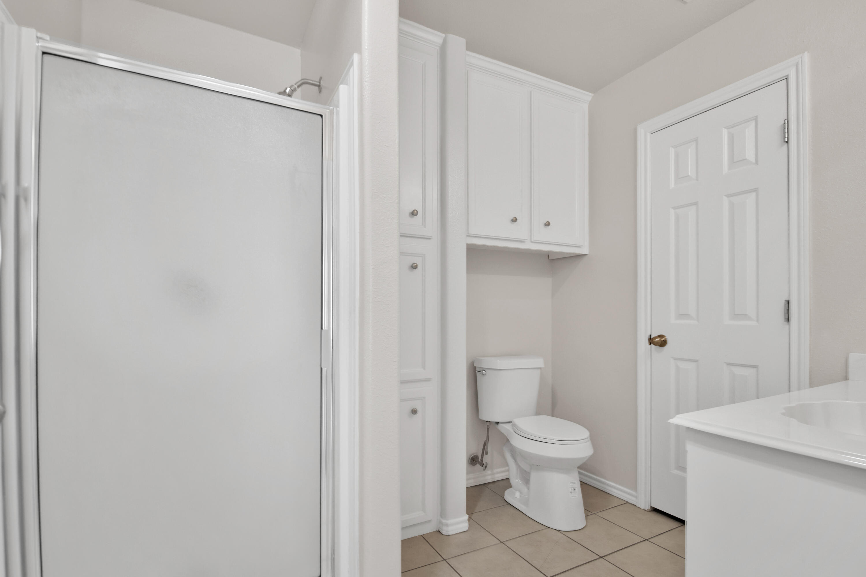 2117 99th Street Lubbock, TX 79423 - Photo 25 of 30 a white toilet sitting next to a bathroom sink