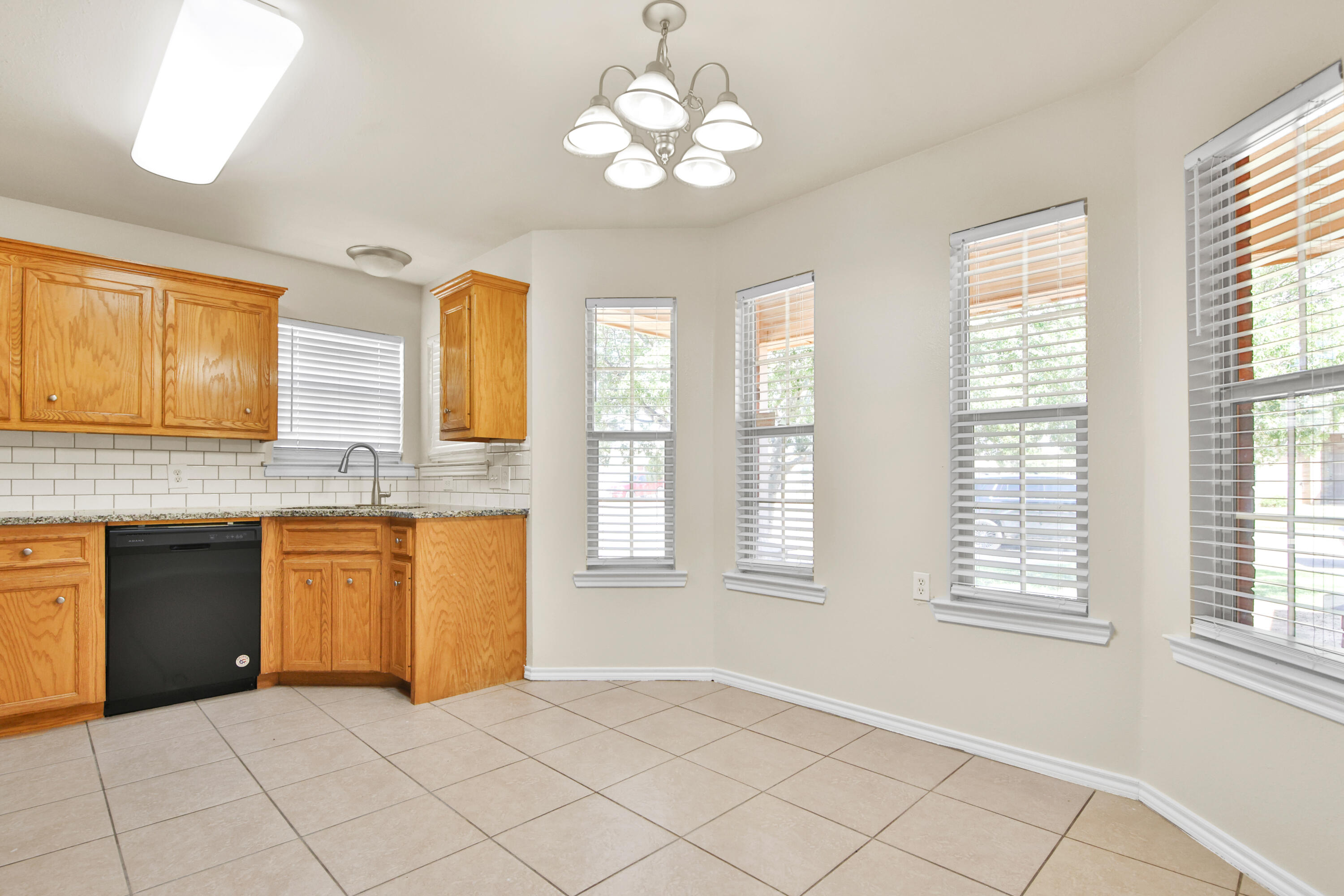 2117 99th Street Lubbock, TX 79423 - Photo 5 of 30 a view of a kitchen with granite countertop cabinets and a large window