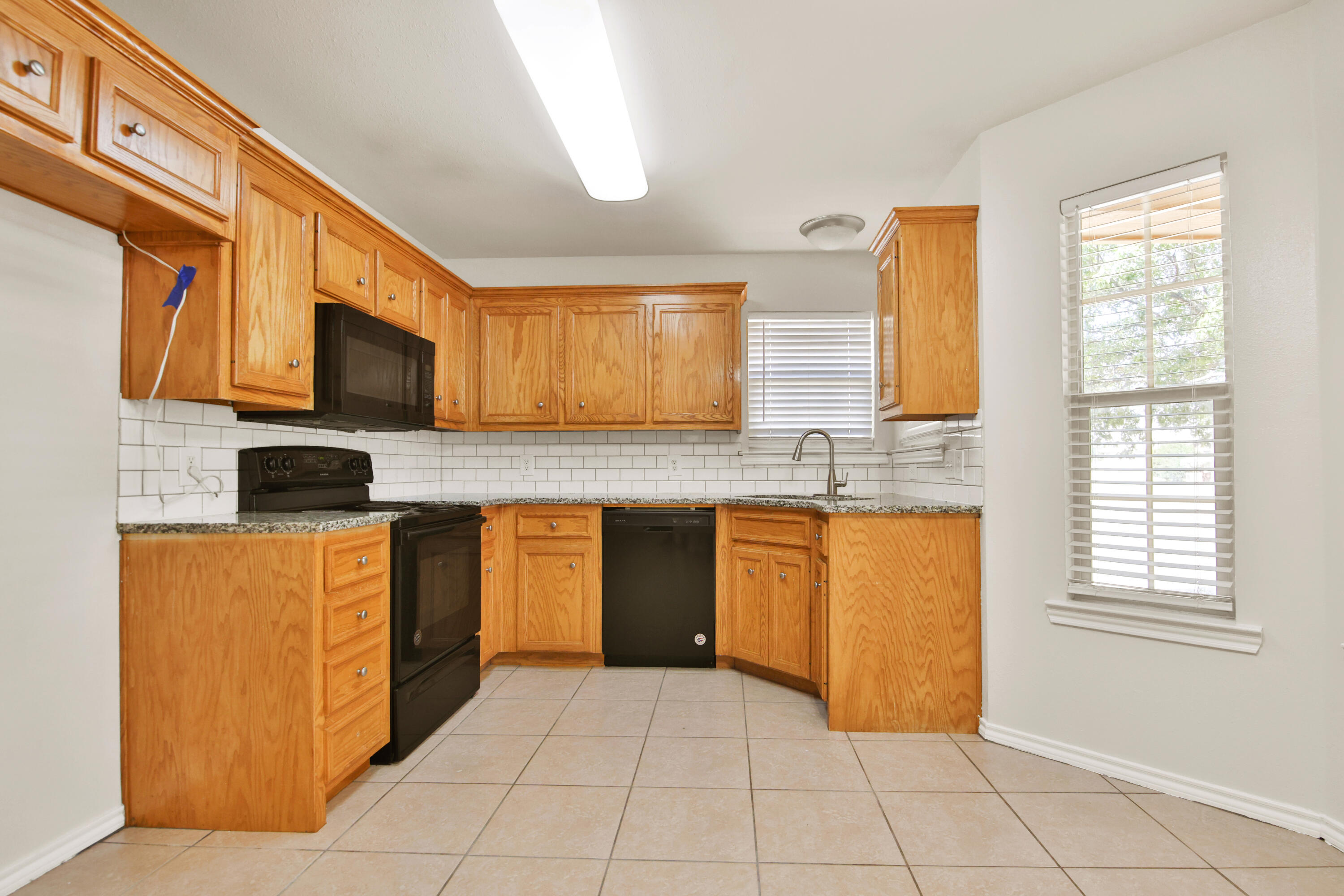 2117 99th Street Lubbock, TX 79423 - Photo 6 of 30 a kitchen with stainless steel appliances granite countertop a stove a sink and a microwave