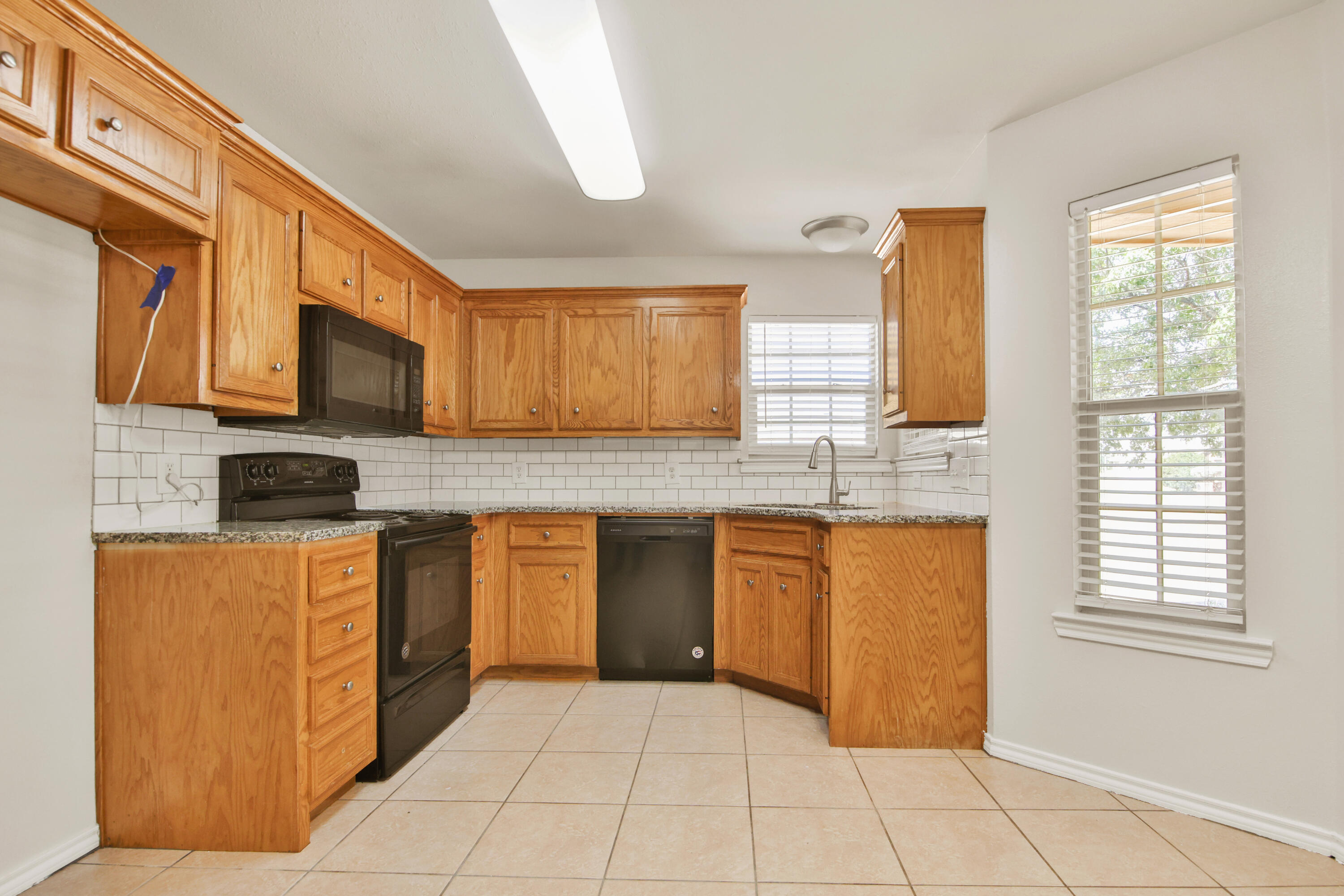2117 99th Street Lubbock, TX 79423 - Photo 7 of 30 a kitchen with stainless steel appliances granite countertop a stove a sink and a microwave