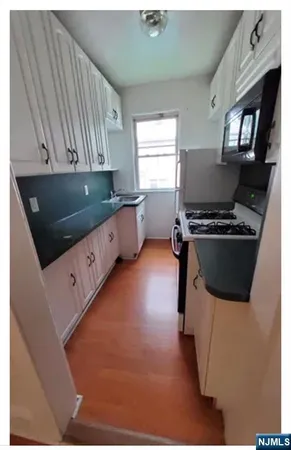 a kitchen with stainless steel appliances kitchen island granite countertop a stove a sink and a microwave