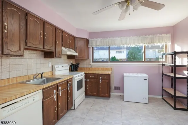 a kitchen with a sink cabinets stainless steel appliances and a window