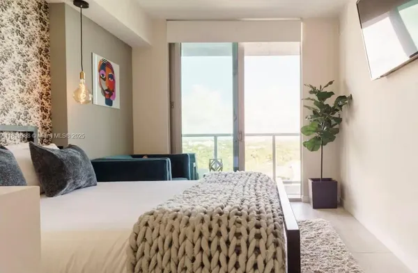 a bedroom with a bed and a large window