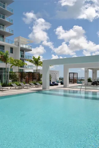 a view of swimming pool with outdoor seating and a garden