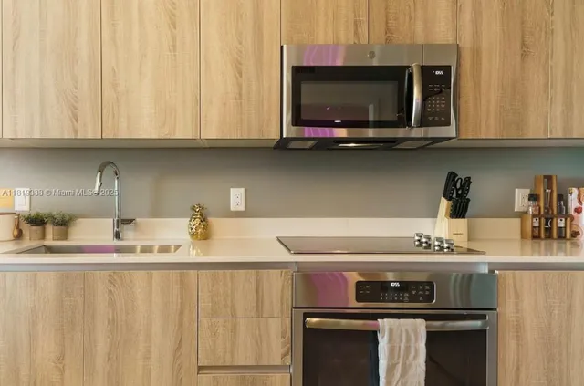 a kitchen with stainless steel appliances a stove a microwave a sink and cabinets