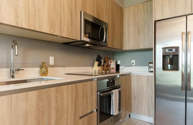 a kitchen with stainless steel appliances granite countertop a refrigerator a stove a sink and dishwasher