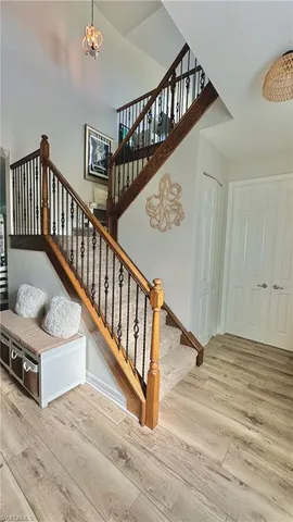 a view of staircase with lots of frames on wall and wooden floor