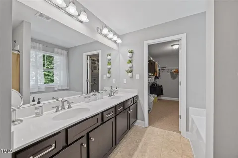 a en suite bathroom with a double vanity sink a mirror and a shower