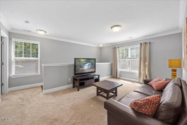 a living room with furniture a window and a flat screen tv