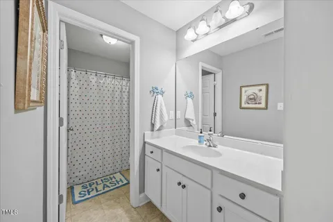 a bathroom with a sink a light fixture and a mirror
