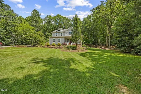 a backyard of a house with table and chairs