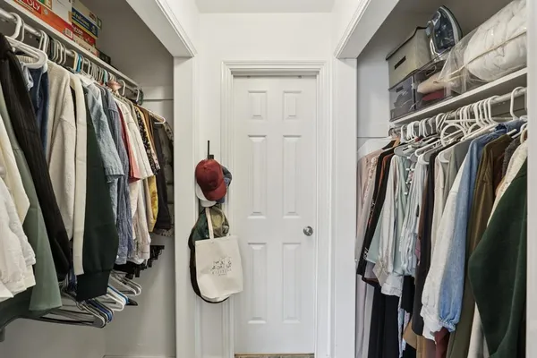 a view of walk in closet with clothes