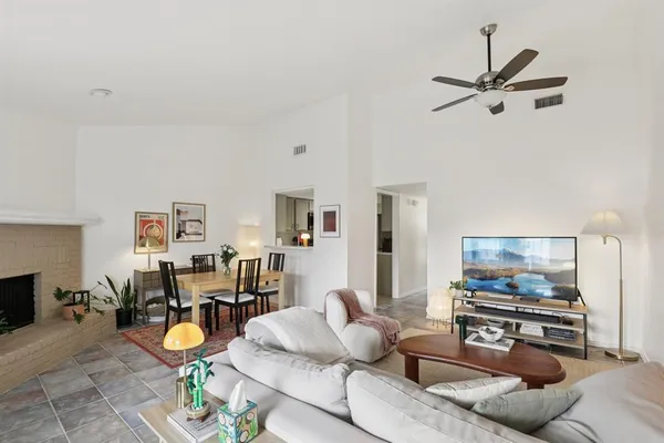 a living room with furniture and a flat screen tv with kitchen view