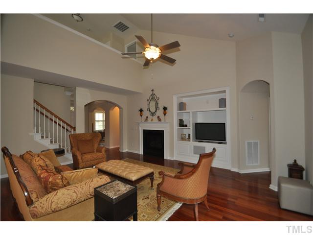 6217 Oconner Street Raleigh, NC 27617 - Photo 4 of 17 a living room with furniture a fireplace and a chandelier