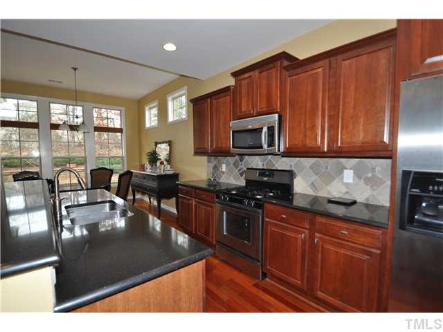 6217 Oconner Street Raleigh, NC 27617 - Photo 6 of 17 a kitchen with granite countertop a stove a sink a counter space and cabinets