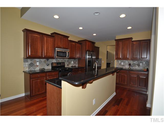 6217 Oconner Street Raleigh, NC 27617 - Photo 7 of 17 a kitchen with wooden cabinets and stainless steel appliances