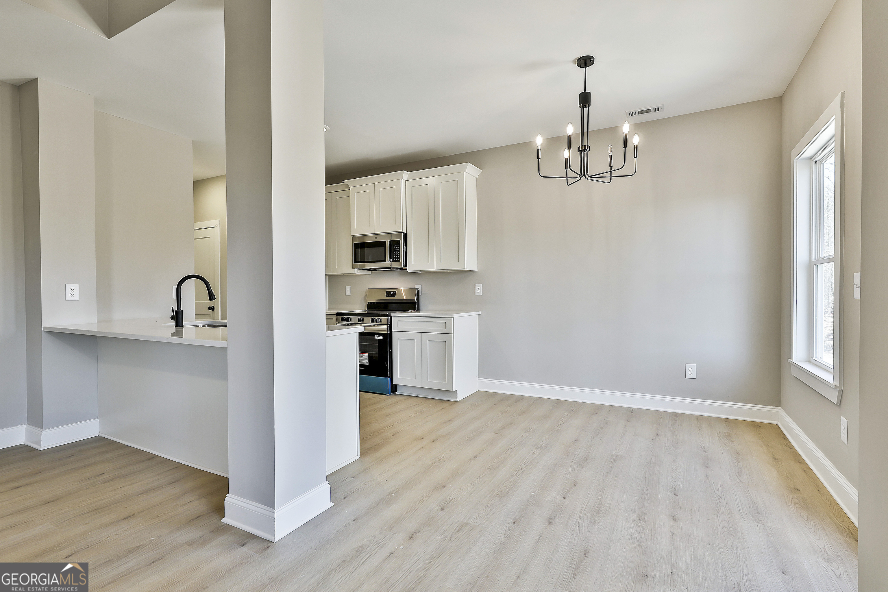35 Oak Road Locust Grove, GA 30248 - Photo 12 of 36 a view of a kitchen with wooden floor and stainless steel appliances
