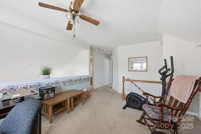 a view of a room with furniture and a ceiling fan