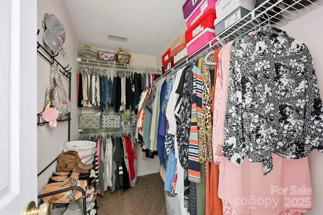 a view of walk in closet with clothes