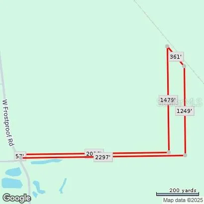 a view of a dirt road with trees in the background