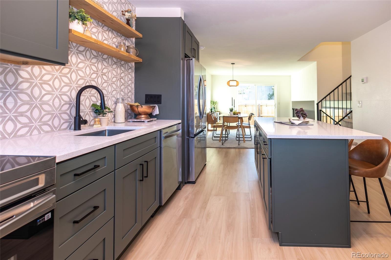5711 West 92nd Avenue, Unit 20 Westminster, CO 80031 - Photo 4 of 26 a kitchen with granite countertop a stove a sink dishwasher and cabinets with wooden floor