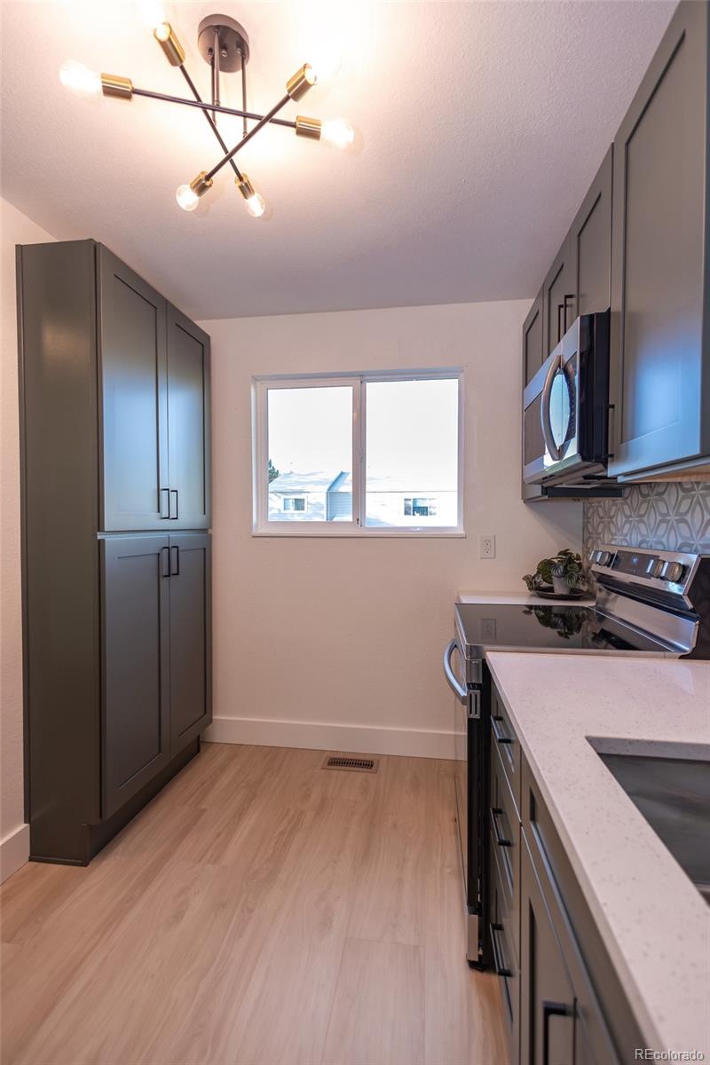 5711 West 92nd Avenue, Unit 20 Westminster, CO 80031 - Photo 5 of 26 a kitchen with a stove and a microwave