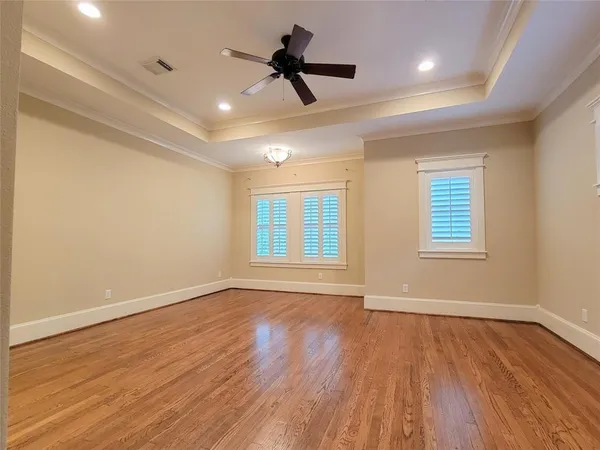 a view of an empty room with a window and wooden floor