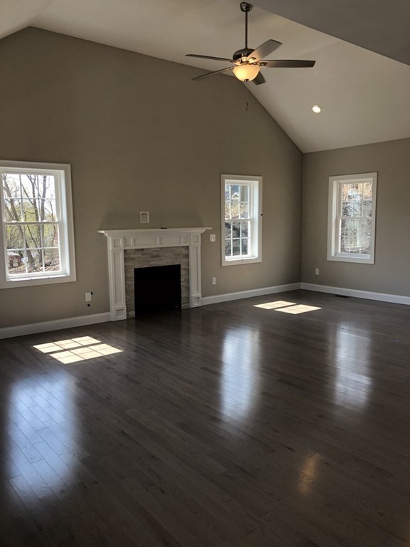 19 Forest Road Salisbury, MA 01952 - Photo 5 of 14 an empty room with wooden floor fireplace and windows