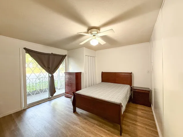 a spacious bedroom with a bed windows and a chandelier