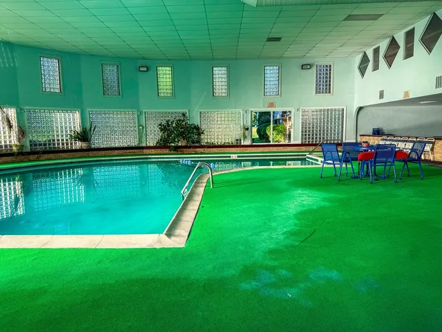 a swimming pool with outdoor seating and yard