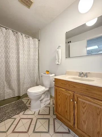 a bathroom with a toilet a sink and a mirror