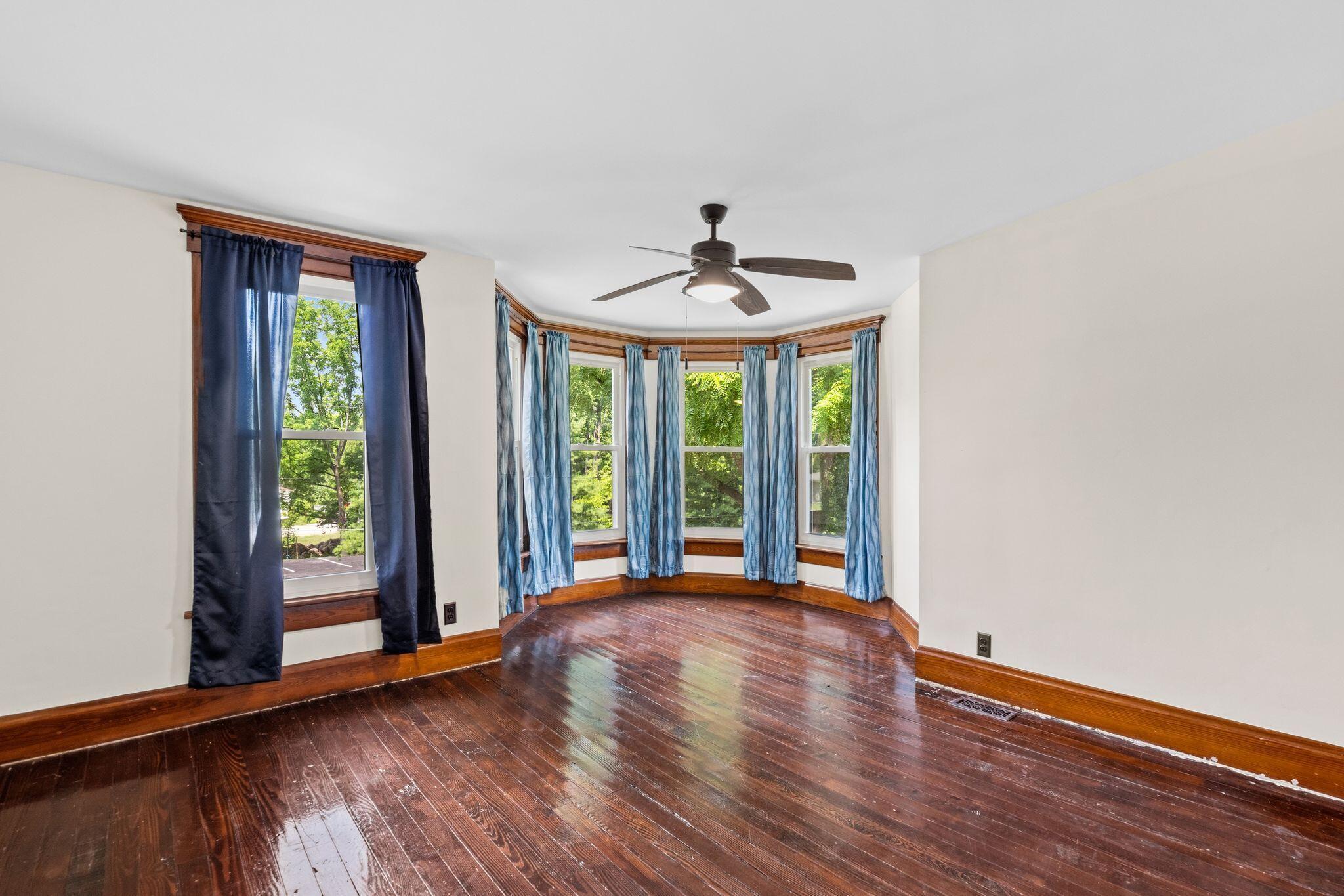 107 Price Road Columbus, OH 43230 - Photo 18 of 51 Room featuring a bay window, hardwood flooring, and a ceiling fan