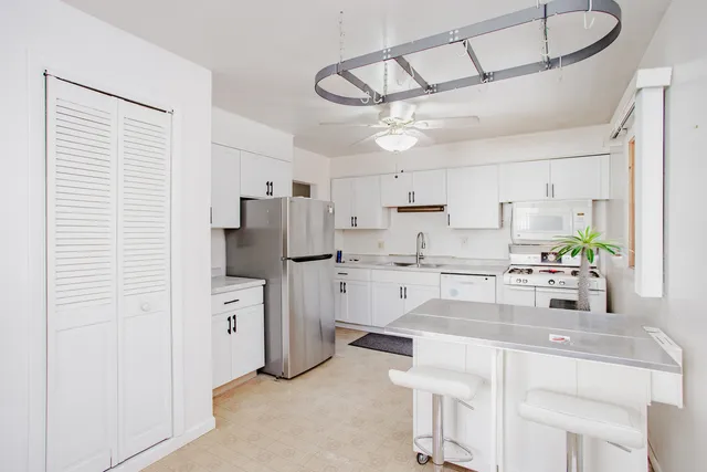 a kitchen with white cabinets and white appliances