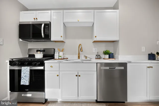 a kitchen with stainless steel appliances granite countertop a sink and a stove