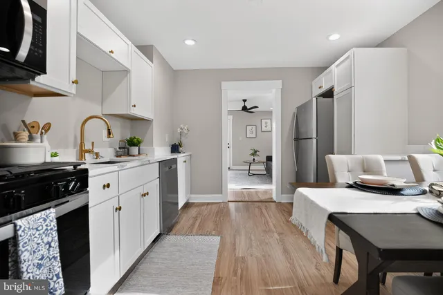 a kitchen with stainless steel appliances a stove a sink a refrigerator and cabinets
