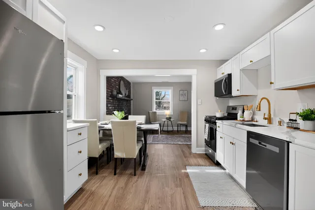 a kitchen with white cabinets and stainless steel appliances
