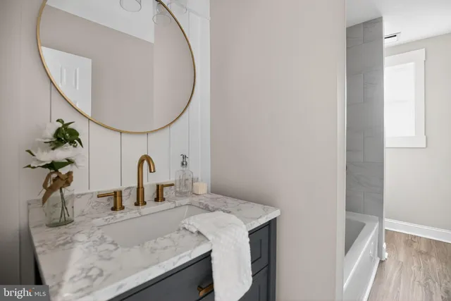 a bathroom with a granite countertop sink and a mirror