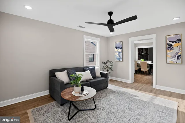 a living room with furniture and a wooden floor
