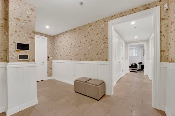 a hallway with white cabinets and wooden floor