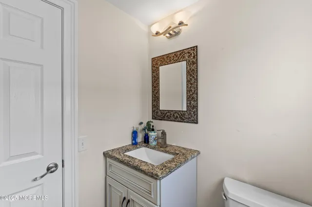 a bathroom with a granite countertop sink and a mirror
