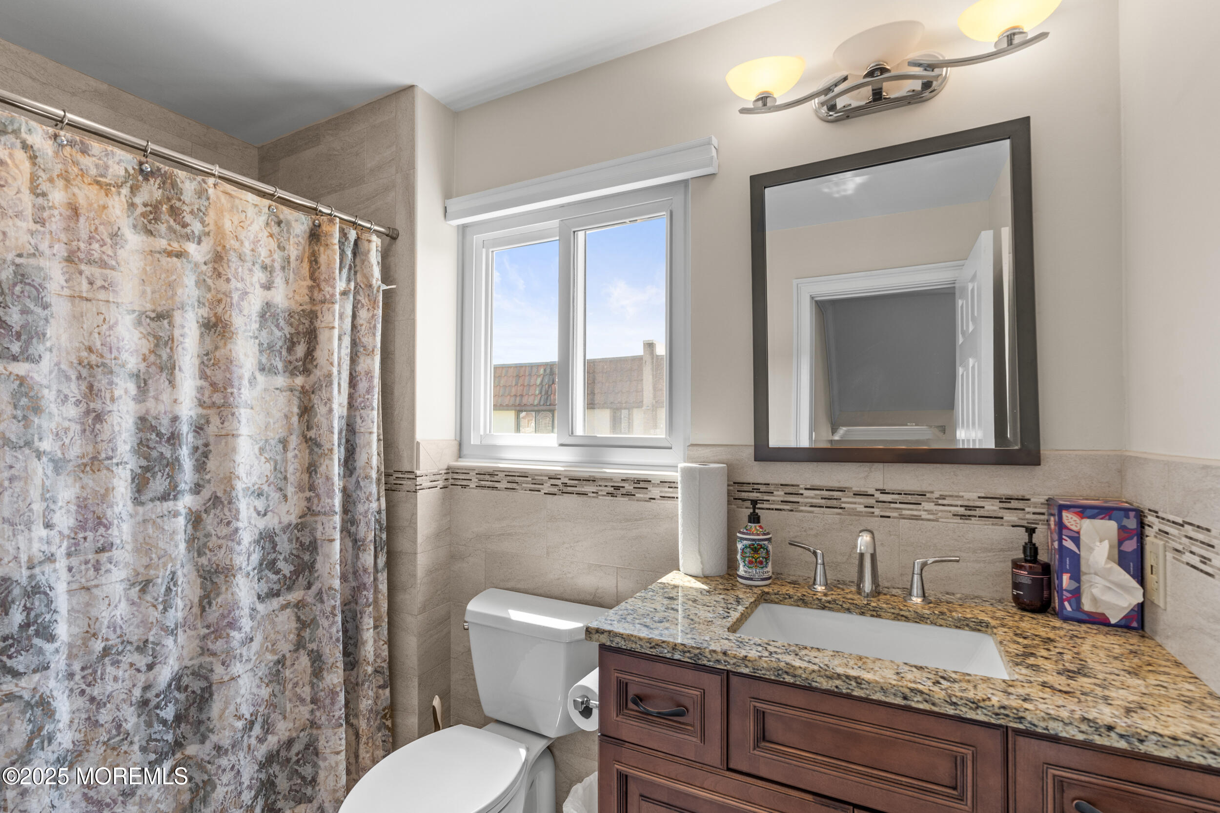 450 Ocean Boulevard, Unit 8 Long Branch, NJ 07740 - Photo 15 of 33 a bathroom with a granite countertop sink mirror vanity and toilet